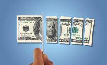 Front view of one hundred dollar banknotes, slicing with a knife on hand, isolated on white background.
